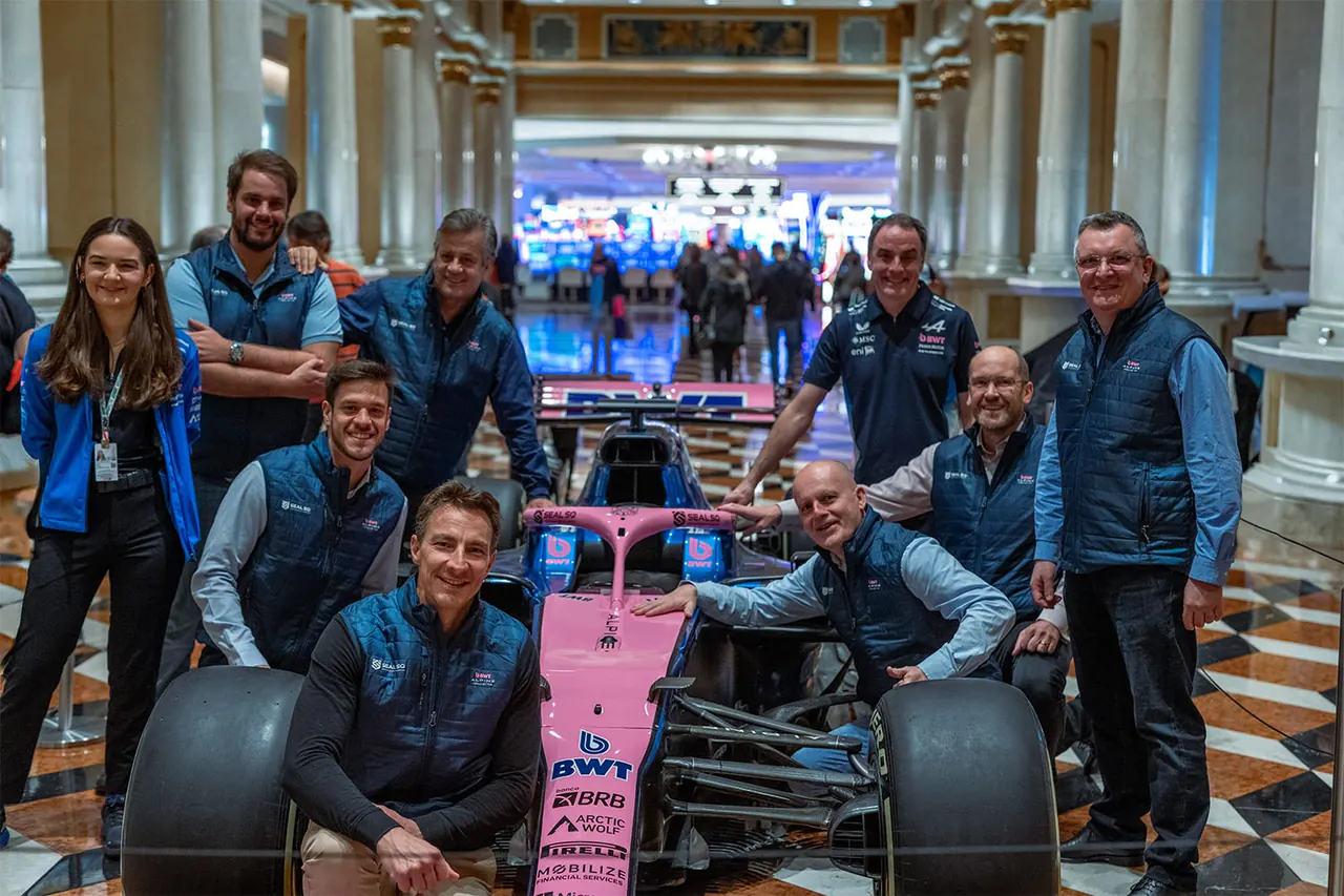 The SEALSQ team beside a BWT Alpine Formula One show car carrying SEALSQ branding on its nose.